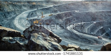 Work of trucks and the excavator in an open pit on gold mining, soft focus Foto d'archivio © 