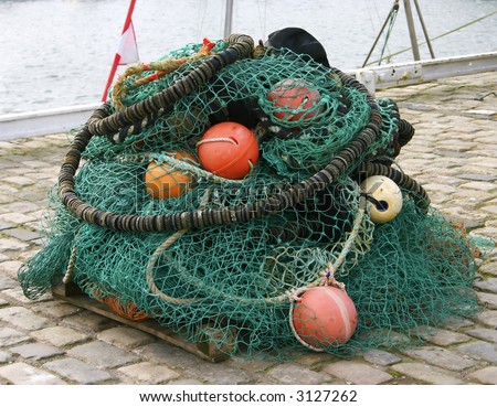 A large collection of fishing nets and floats in a commercial harbour