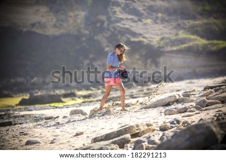 woman walks alone on a deserted beach at sunset time