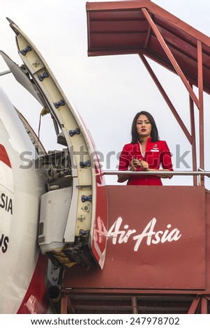 BALI, INDONESIA - JANUARY 17, 2015: Stewardess of Air Asia airlines in Bali airport on January 17, 2015. Air Asia company is the largest low cost airlines in Asia.