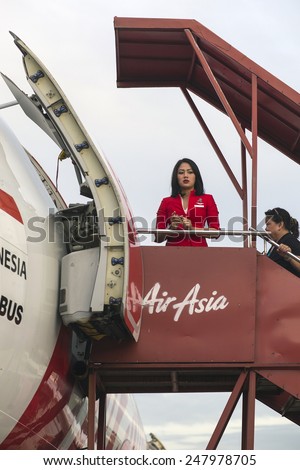 BALI, INDONESIA - JANUARY 17, 2015: Stewardess of Air Asia airlines in Bali airport on January 17, 2015. Air Asia company is the largest low cost airlines in Asia.