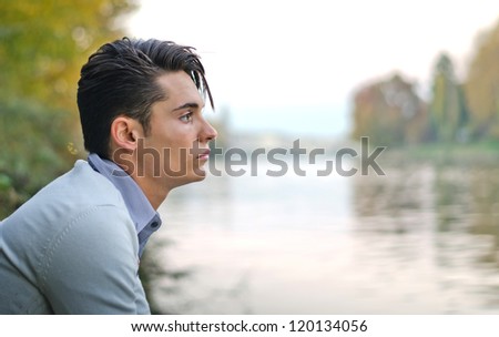 Profile portrait of handsome young male model on river banks