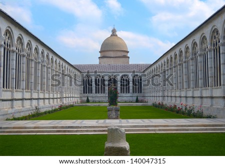 Historical courtyard garden with arched building around it and green lawn