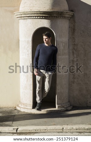 Handsome young man posing in guard\'s booth in front of old building