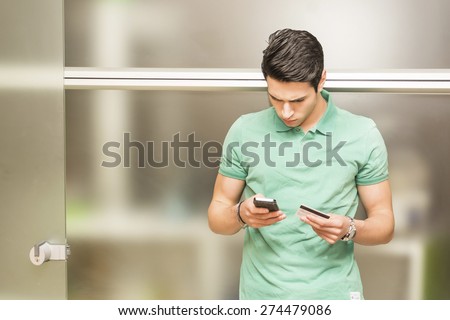 Attractive young man paying bills or buying things on e-commerce sites through credit card