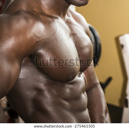 Attractive hunky black male bodybuilder doing bodybuilding pose in gym