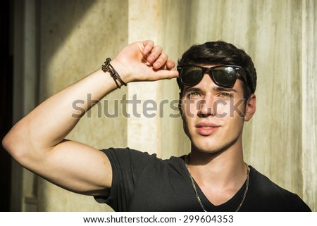 Head and shoulder shot of handsome attractive young man looking up, indoor, lit by sunlight