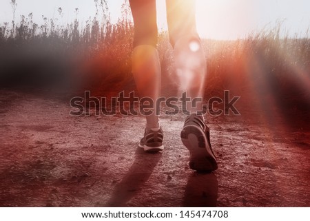 African woman on Gravel road running at sunrise
