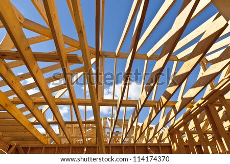 House construction with wood framing and roof trusses against a blue sky for your dream home.