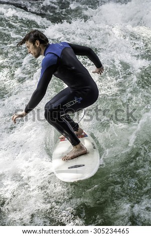 MUNICH - AUGUST 08: An unidentified man surfer works the wave at the Surf & Style 2015 Anniversary August 08, 2015 in Munich.