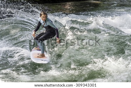 MUNICH - AUGUST 08: female surfer works the wave at the Surf & Style 2015  Anniversary August 08, 2015 in Munich.
