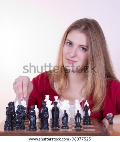 Beautiful woman in red sweater taking her move in chess.
