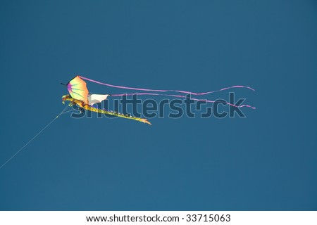 Kite in the shape of flying dragon on the blue sky background