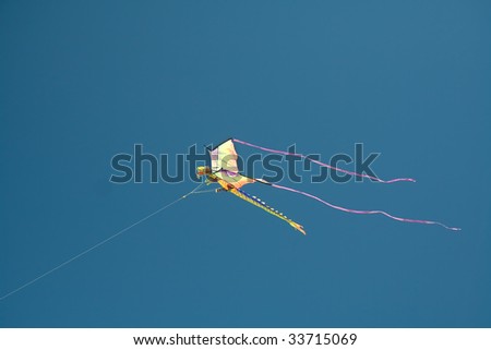 Kite in the shape of flying dragon on the blue sky background