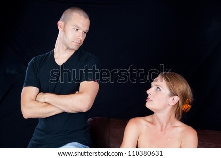 Couple together and angry at each other, he has his arms crossed and they are glaring at each other