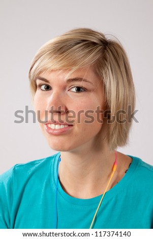 Pretty blond woman wearing a teal blouse, with a happy, friendly smile for the camera and good eye contact