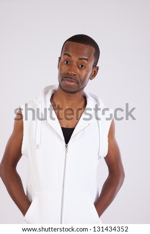 Handsome black man sitting with a puzzled look on his face and his hands in his sweatshirt pockets