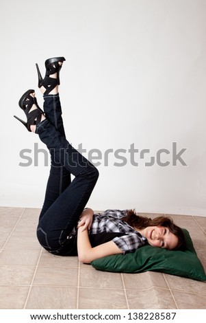 Pretty white woman reclining on her back with her legs up in the air and looking at the camera with a friendly, happy expression