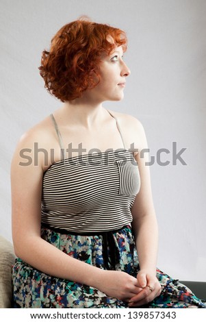 Lovely redhead woman looking to the right with thoughtful expression