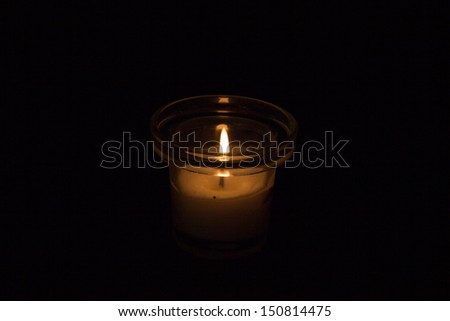 Single candle in a glass jar