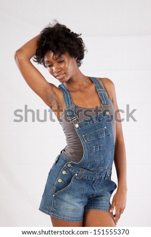 Pretty black woman in blue jean overall shorts, posing with a serious, thoughtful, pensive, expression
