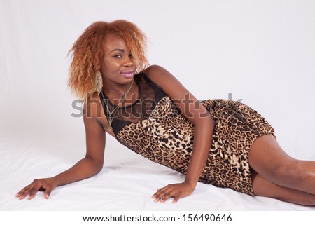 Pretty black woman laying   on the floor and looking right