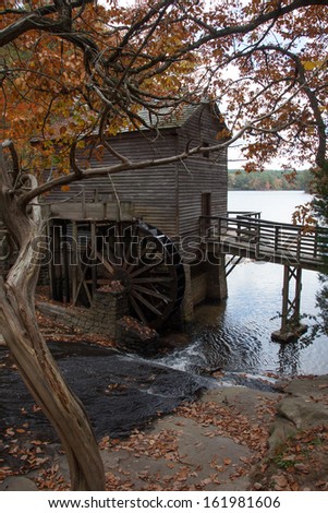Old grist mill, with a water driven wheel to grind and a creek beside, flowing over stones