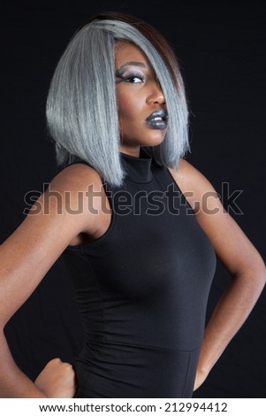 Pretty black woman wearing a blue long blouse with a thoughtful expression, looking at the camera
