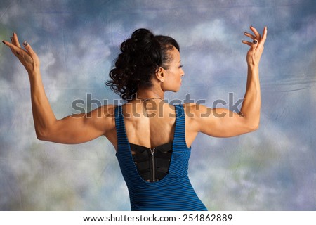 Pretty strong woman from the back, flexing her muscles