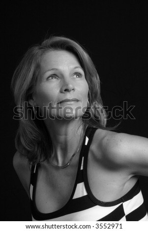 Lovely mature woman looking up and left in black and white.