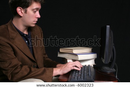 Businessman working on computer with books