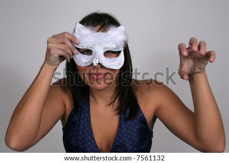 Woman holding a cat mask to her face and making like a cat