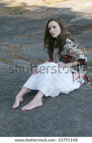 Lovely lady sitting on a stone