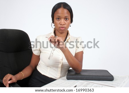 Pretty African American woman pondering at her desk with eye contact