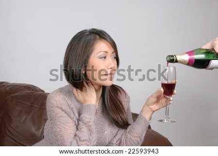 Wine being poured for a pretty asian american woman