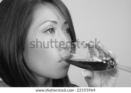 black and white photo of asian american woman drinking wine from a glass