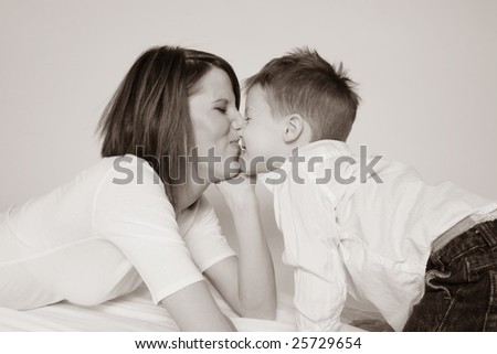 Sepia tone of mother and son kissing