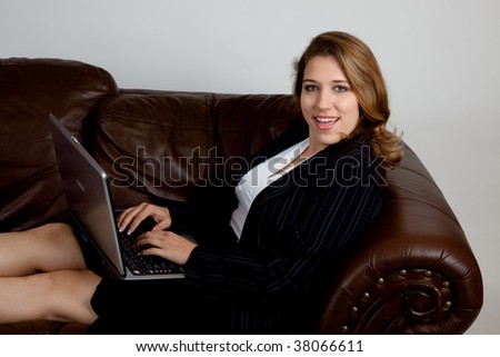 Businesswoman on couch with a laptop and a smile