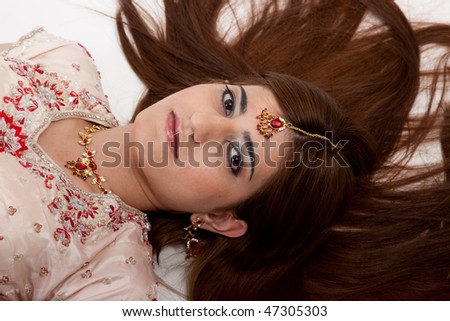 Lovely indian woman in traditional dress, laying on floor