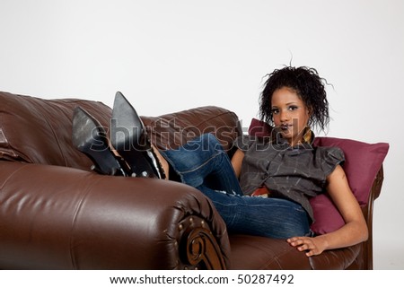 Lovely African American woman happy and reclining on a couch