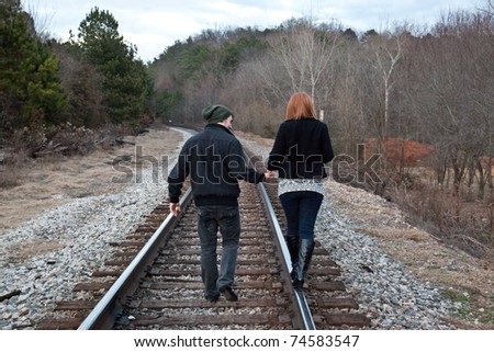 Couple walking down the rail road tracks