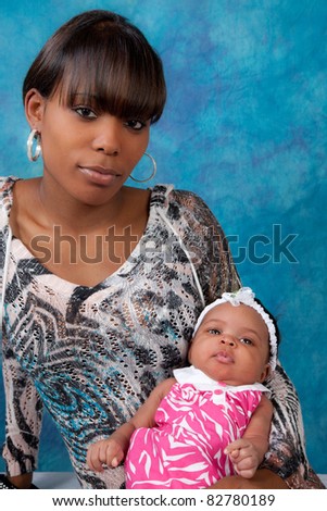 Pretty black mother holding her young daughter