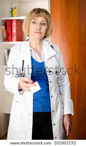 Mature doctor woman giving business card