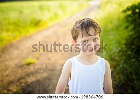 funny little boy on a country road with an innocent expression on his face