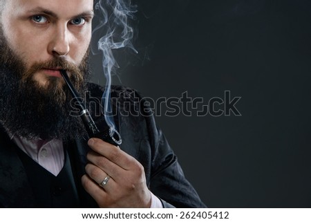 Portrait of a man with a beard smoking a pipe. A man dressed in an elegant black jacket and bright pink shirt