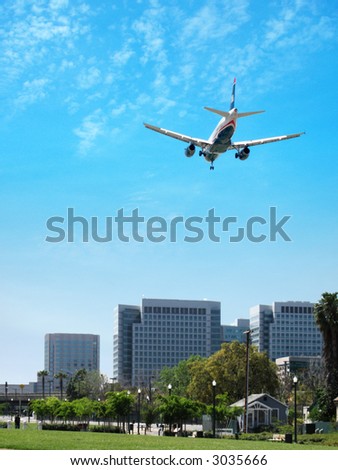Airplane Landing ; brilliant blue sky, park and cityscape, being, commuter, skyline,