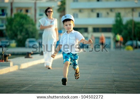 Little boy and his mother running at jetty