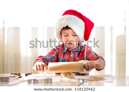 Little boy with rolling pins baking and having fun, Merry Christmas