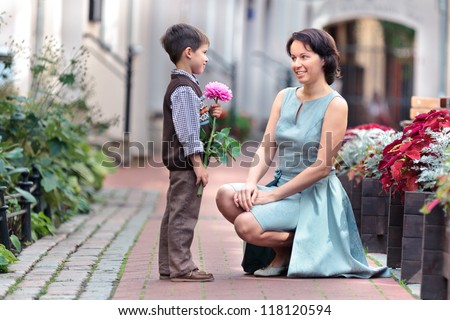 Little boy giving flower to his mom on mother\'s day