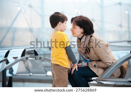 Loving mother and son at airport, going on holiday